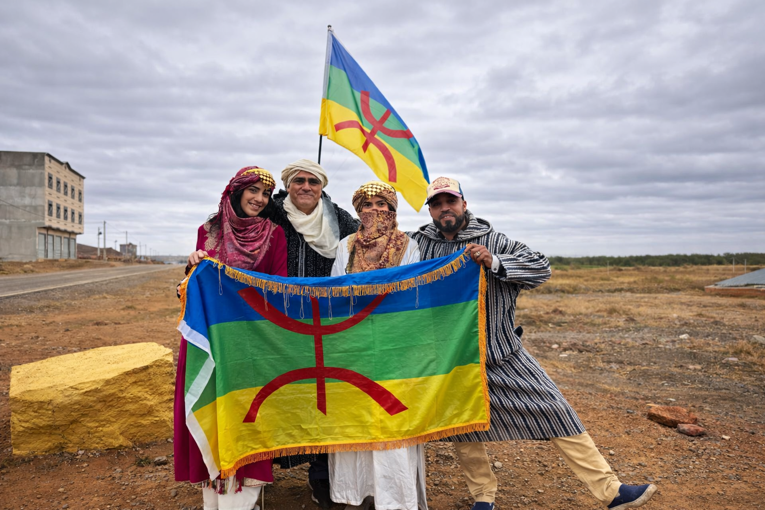 Amazigh Cultural Experience in Morocco Amazigh guide with foreign visitors wearing traditional Amazigh clothing and holding the Amazigh flag in Morocco